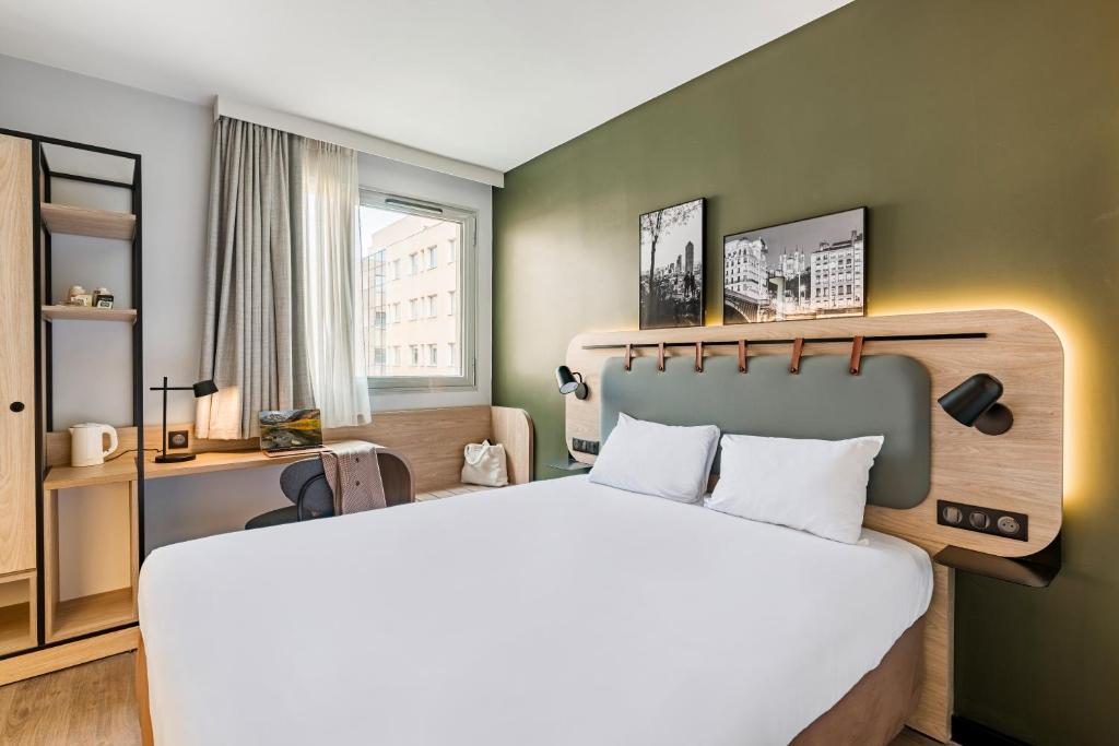 Un dormitorio con una cama grande y una pared verde. en Campanile Lyon Centre Part-Dieu, en Lyon