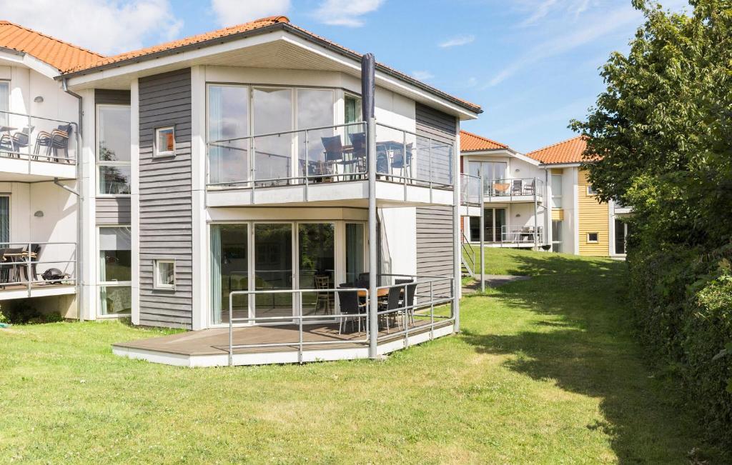 a large house with a balcony and a yard at Gudhjem Søpark Lejl 38 in Gudhjem