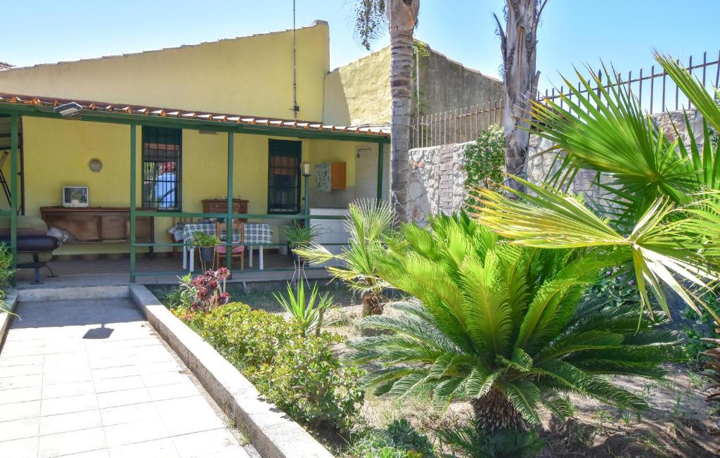 a yellow house with palm trees in front of it at Casa Vacanza Scarantino 1 in Catania
