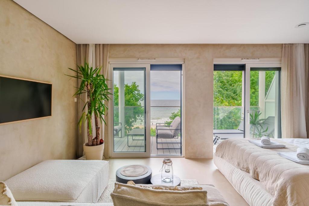 a living room with two beds and a balcony at Boho z Widokiem na Morze by Perłowa Przystań Rent in Sianozety