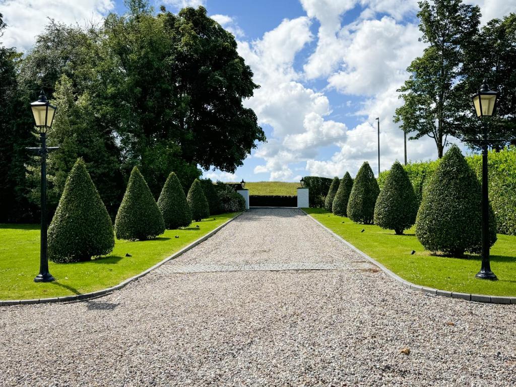 un vialetto con una fila di alberi e un garage di Large and luxurious country home near Glasgow a Eaglesham