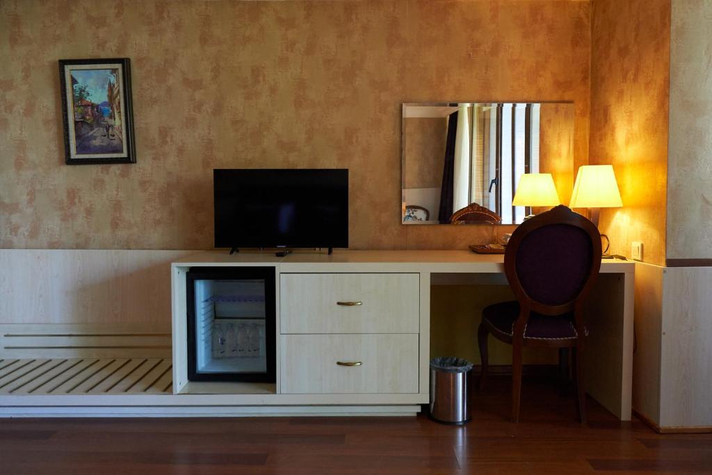 a room with a desk with a television and a chair at Phellos Suites Boutique Hotel in Şile