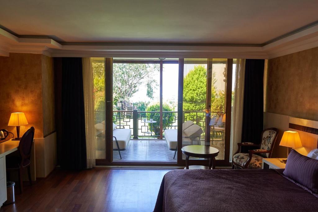 a bedroom with a bed and a balcony with a view at Phellos Suites Boutique Hotel in Şile