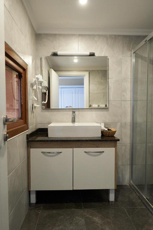 a bathroom with a sink and a mirror at Phellos Suites Boutique Hotel in Şile