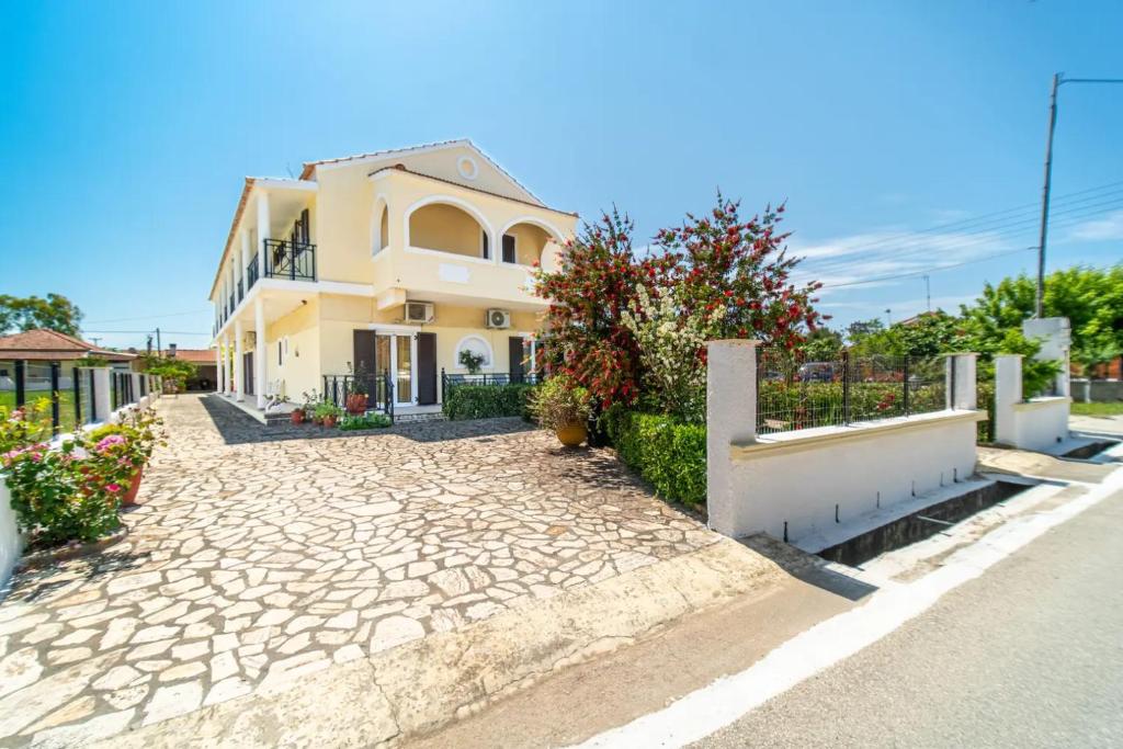 a house with a stone driveway in front of it at Olga Apartments in Agios Georgios