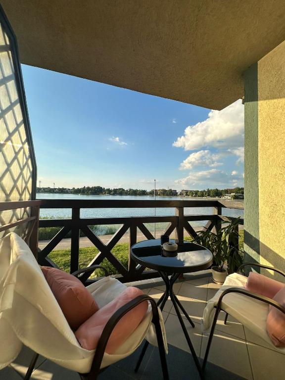 a balcony with chairs and a table and a view of the water at Chillout u Oli Apartament nad samym jeziorem in Ostróda