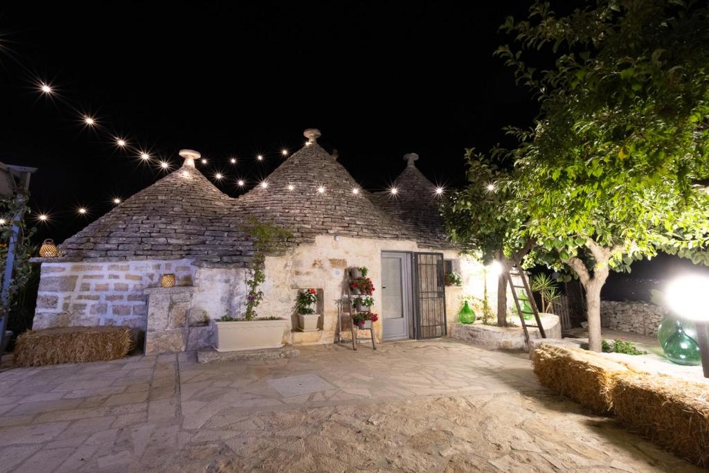 a stone building with lights on it at night at Trulli Arborea in Alberobello