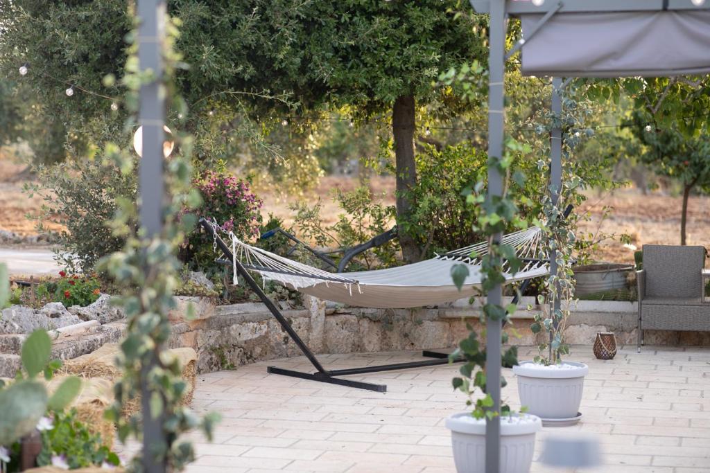 a hammock in a garden with trees and plants at Trulli Arborea in Alberobello
