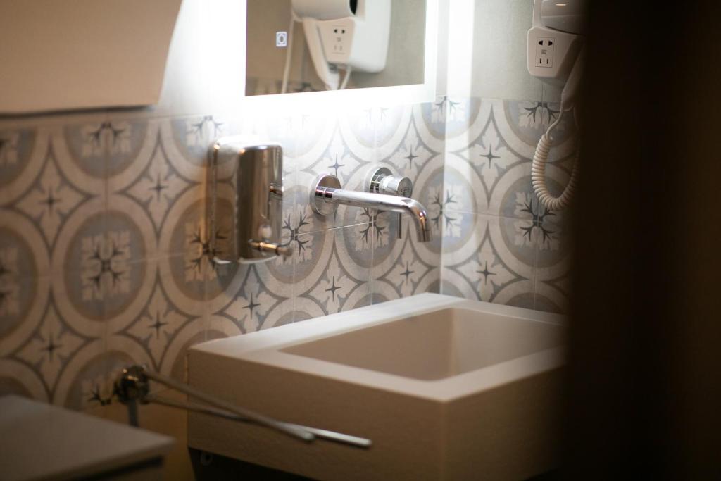 a bathroom with a sink and a mirror at Trulli Arborea in Alberobello