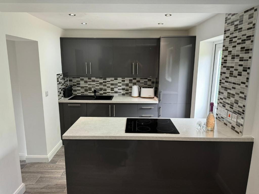 una cucina con mobili neri e un piano di lavoro di 2 Bed Apartment Scarisbrick Street Ormskirk - Rooms by Vici a Ormskirk