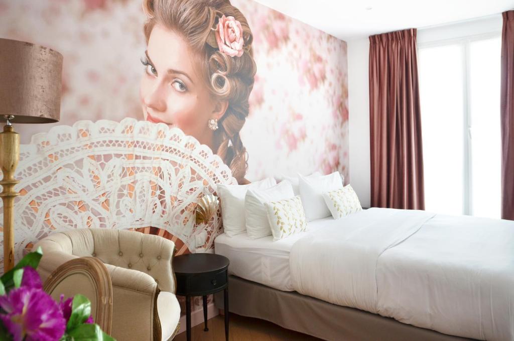 a room with a bed and a painting of a woman at Le Glam's Hotel in Paris