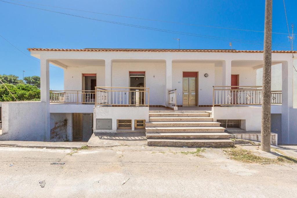 ein weißes Haus mit Treppe und Veranda in der Unterkunft Sisters` house by BarbarHouse in Marina di Mancaversa