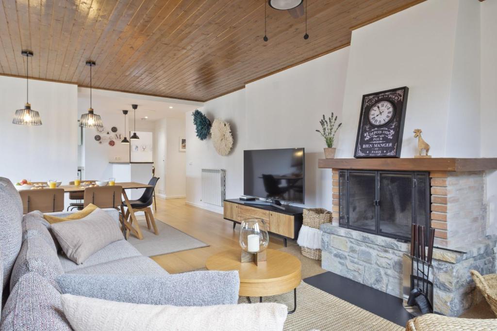 un soggiorno con divano e camino di Luderna - Apartamento Aiguestortes a Vielha