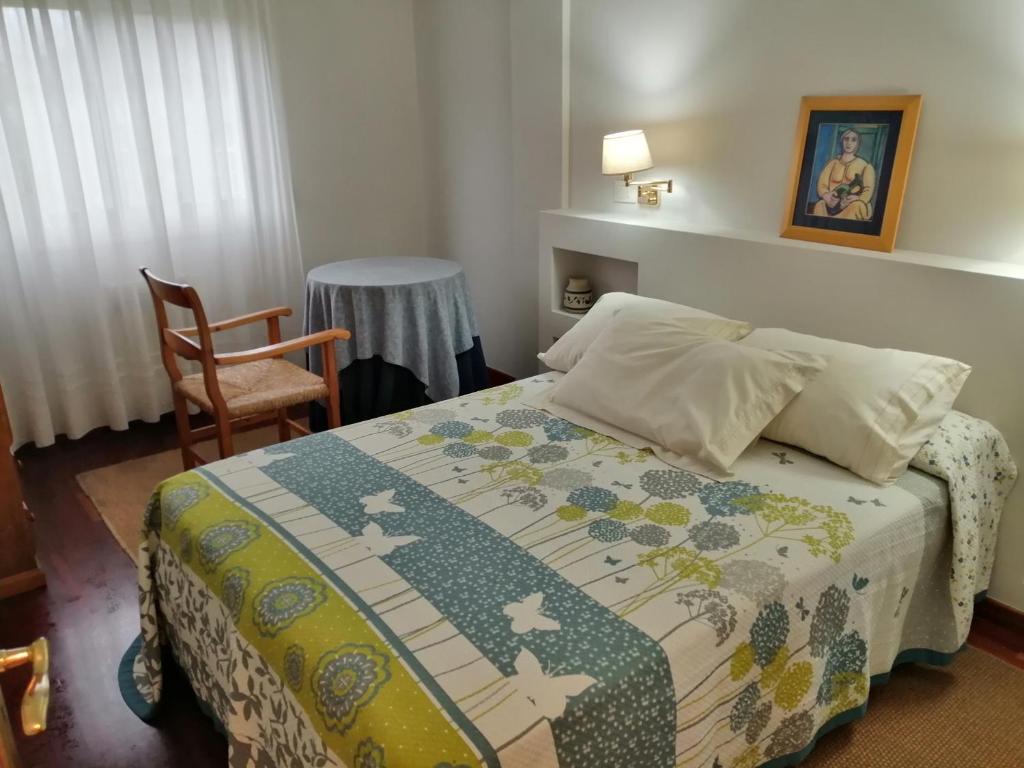 un dormitorio con una cama y una silla en O Piso dos Avós, en A Guarda