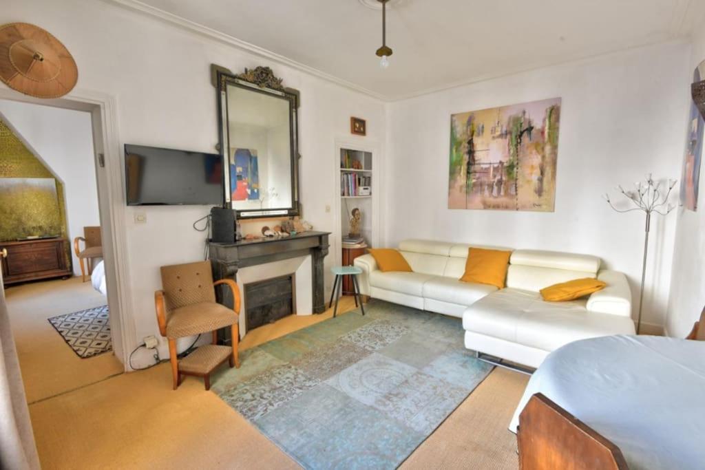 un salon avec un canapé et une cheminée dans l'établissement Coeur Paris authentique, à Paris