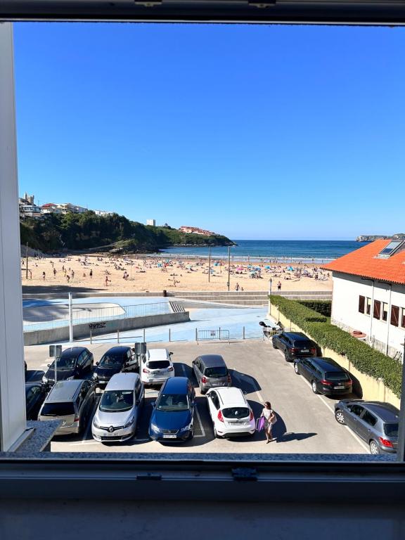 a parking lot with cars parked at the beach at Suances primera línea de playa in Suances