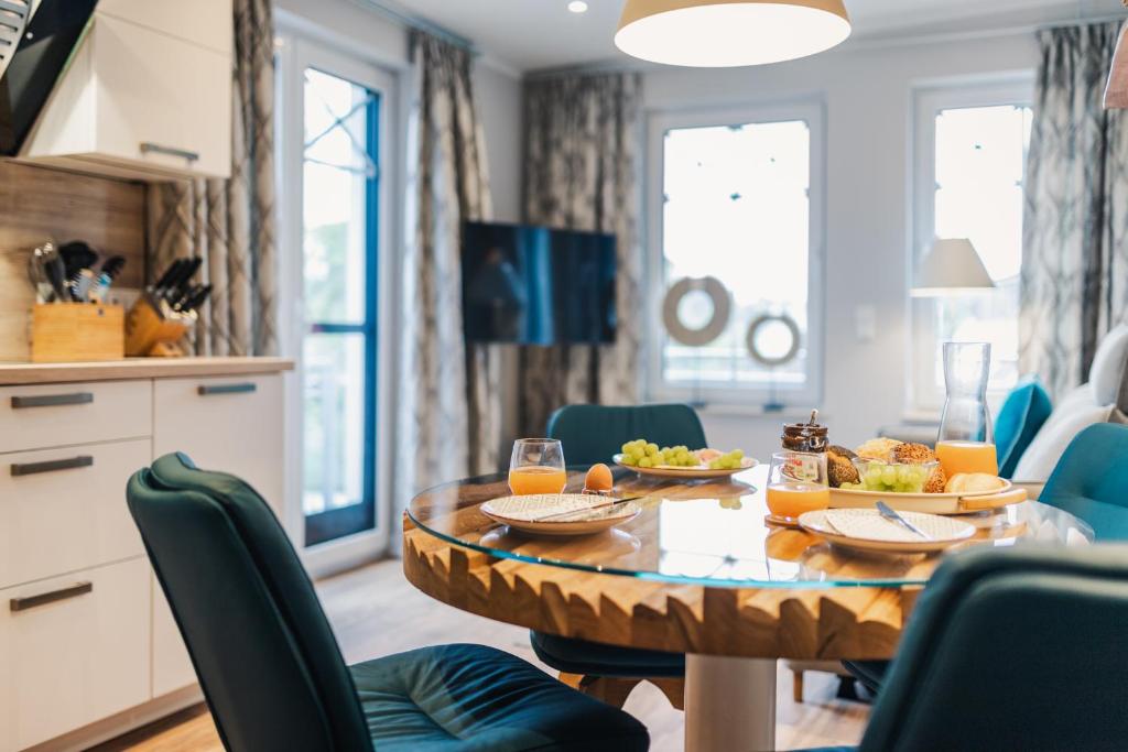 una sala da pranzo con un tavolo con del cibo sopra di Ferienwohnung Auszeit a Zingst