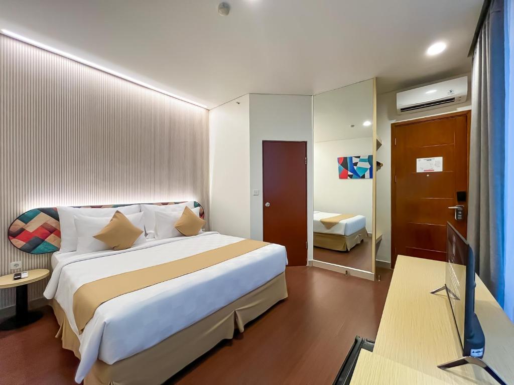 Rúm í herbergi á Hotel 88 Embong Malang Tunjungan Surabaya by WH - Breakfast with The Best View on The Highest Floor and Strategic Location in The City Center
