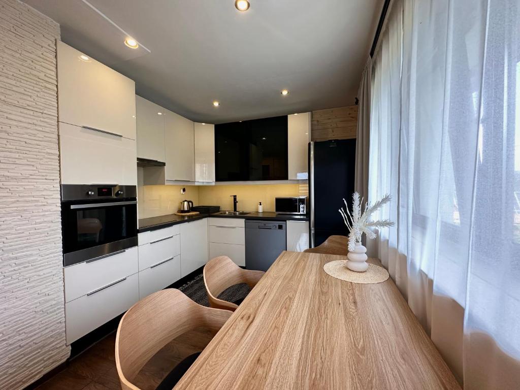 Dom na Wierchu في كوشتيليسكا: مطبخ مع طاولة خشبية وبعض الكراسي