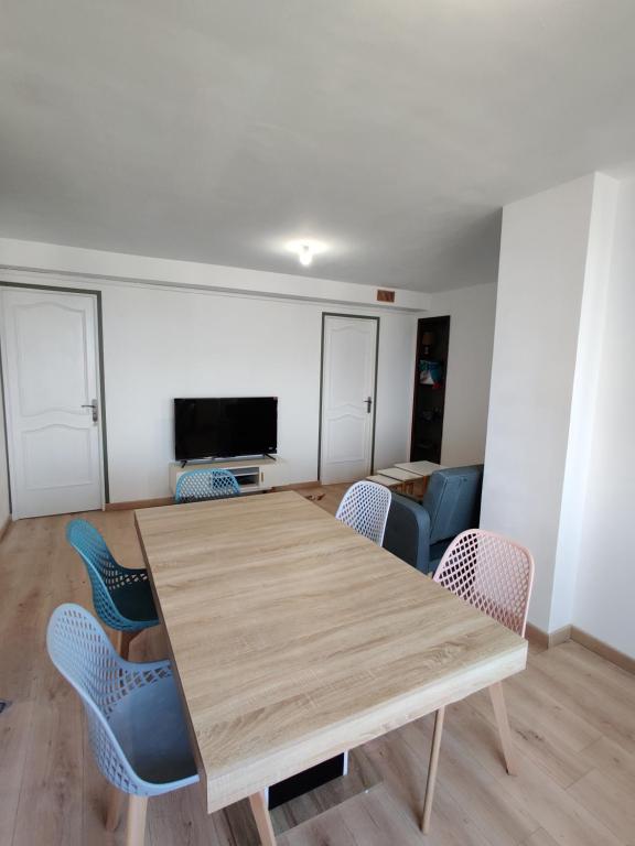 une salle à manger avec une table et des chaises en bois dans l'établissement Charmant T4, Proche des Remparts, à Avignon