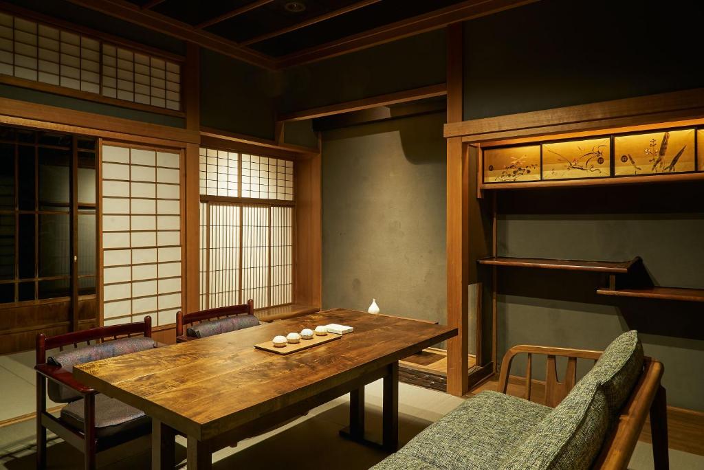 una sala da pranzo con tavolo e sedie in legno di Bed and Craft a Nanto