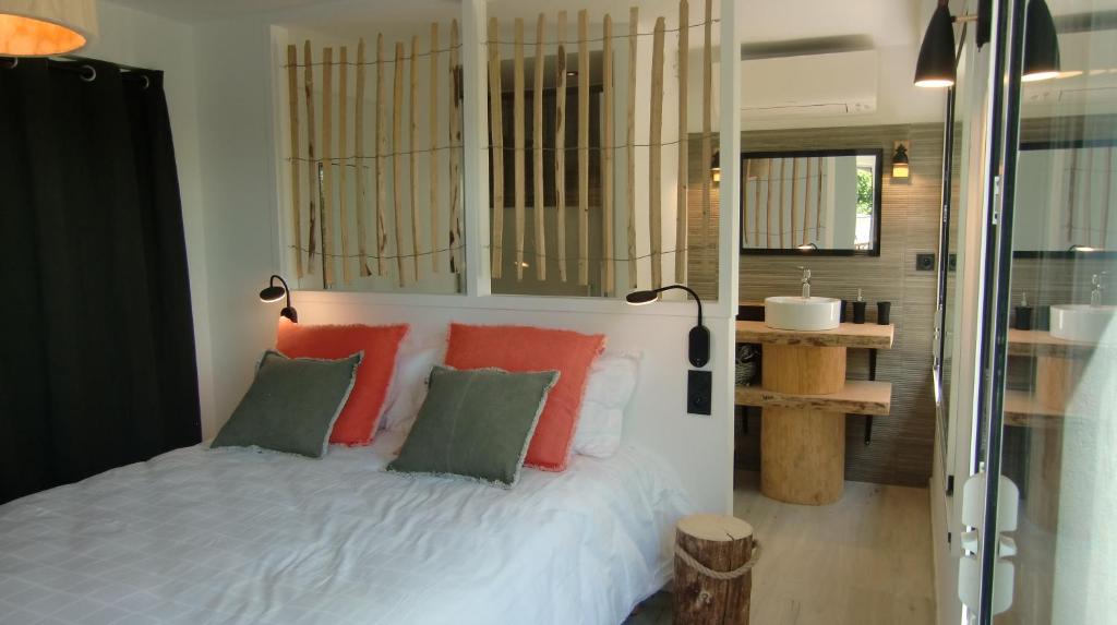 a bedroom with a bed with red and green pillows at Casa Louise - Piscine et jacuzzi privatifs in Sainte-Maxime