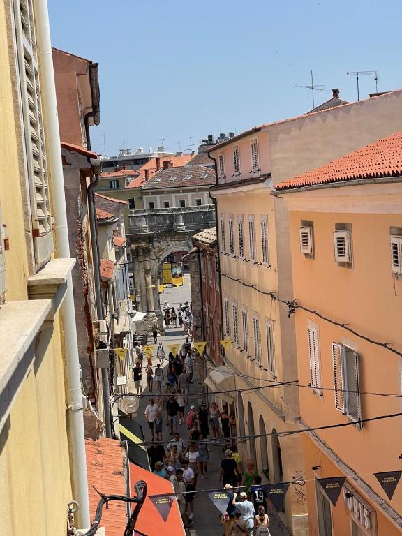 a group of people walking down a city street at Dejan Apartments-Top centar-Old town-Low budget Studios in Pula