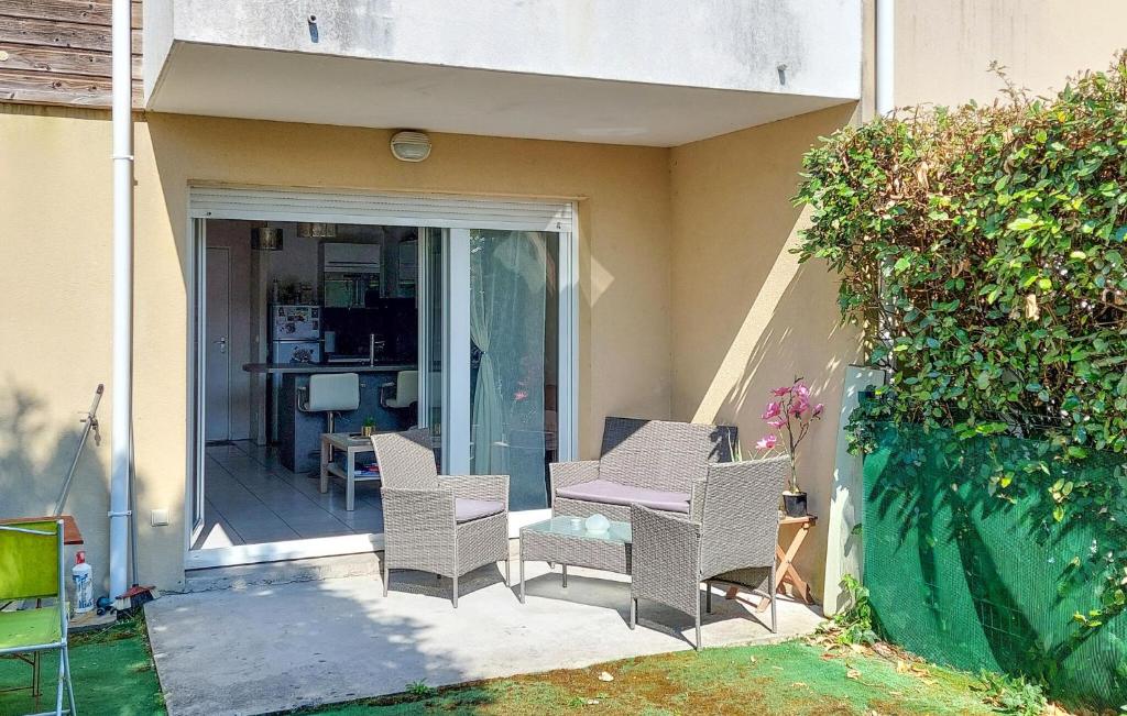 une terrasse avec des chaises en osier et une table sur une maison dans l'établissement 1 Bedroom Cozy Apartment In Audenge, à Audenge