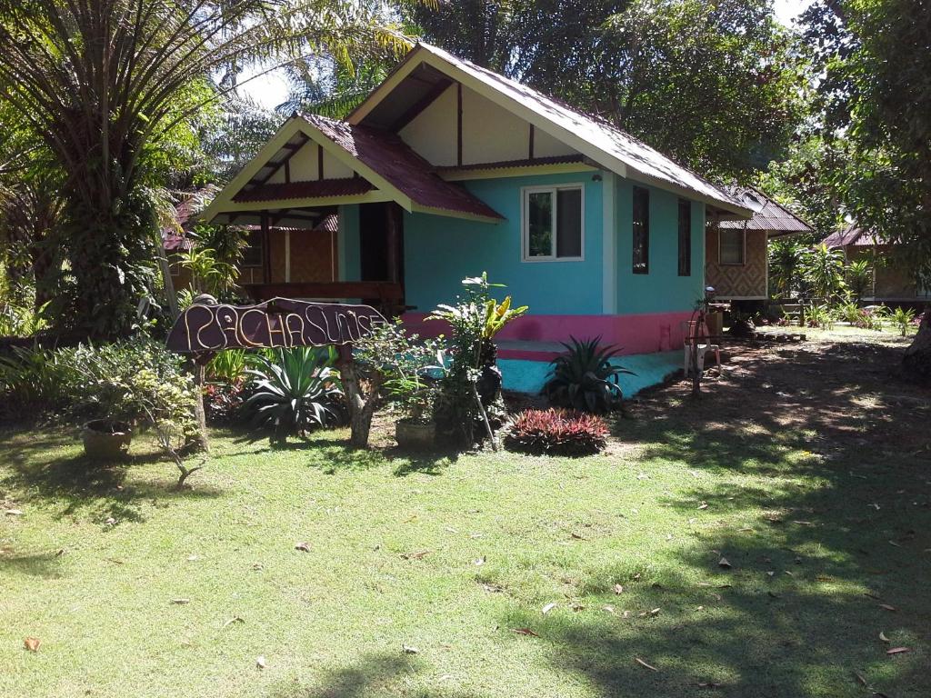 une petite maison bleue avec un panneau devant elle dans l'établissement Racha Sunset Resort, à Siboya