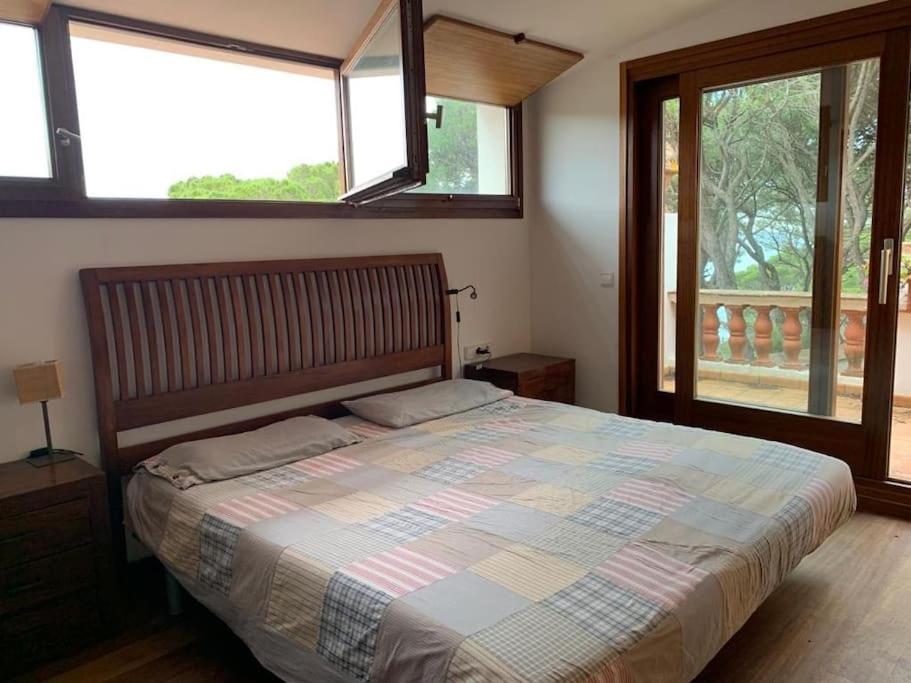 a bedroom with a large bed with two windows at VILLA ANITA 1930 LLAFRANC casa con piscina privada in Llafranc