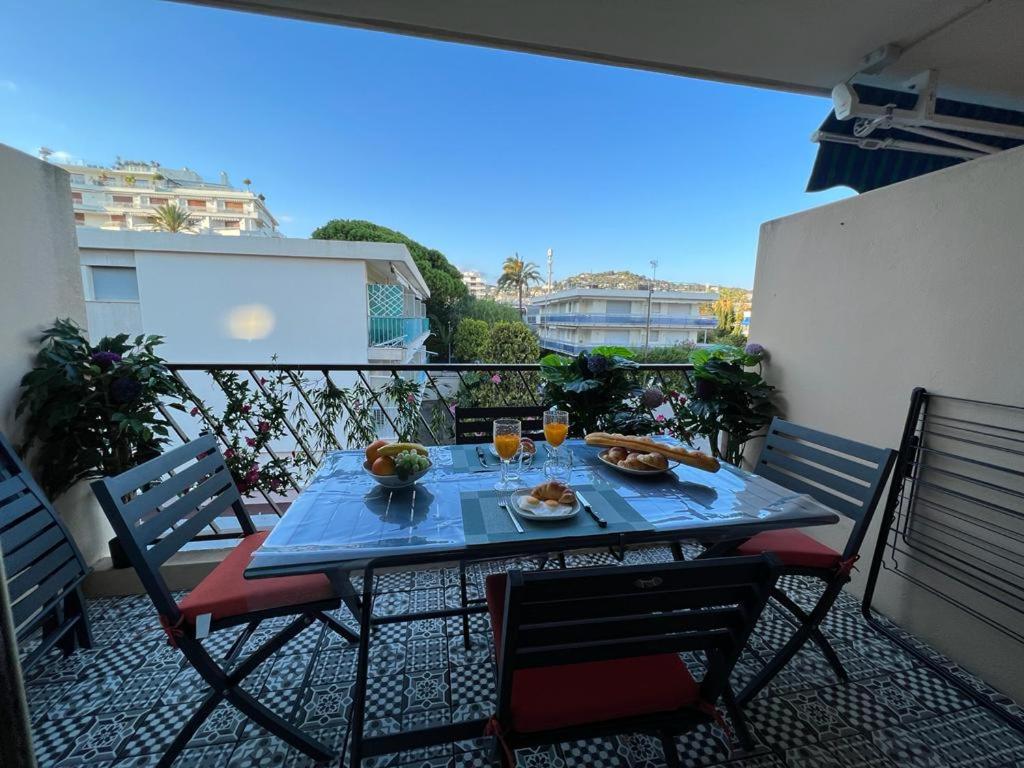 une table avec de la nourriture et des boissons sur un balcon dans l'établissement Beau Soleil Standing Presta, à Cannes