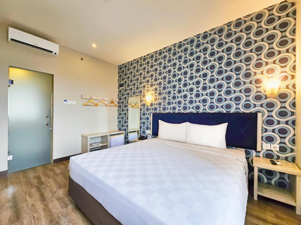 a bedroom with a large bed and a wall at Hotel 88 Kedungsari - Kedungdoro By WH in Surabaya