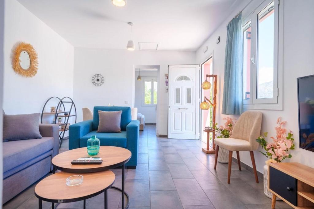 a living room with a blue couch and tables at Villa Spirida at Drakopoulata in Agia Effimia