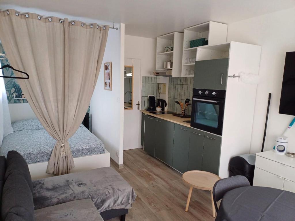 Cette petite chambre comprend un lit et une cuisine. dans l'établissement La chaumière en bord de mer, à Les Sables-dʼOlonne