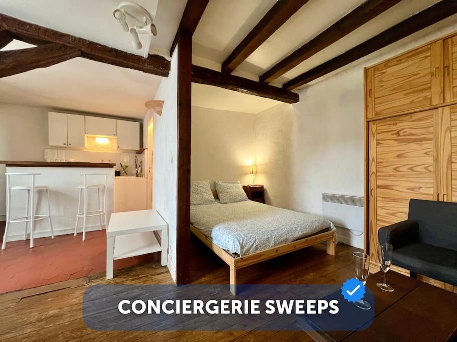 une petite chambre avec un lit et une cuisine dans l'établissement Nid de Fontainebleau - Centre, à Fontainebleau