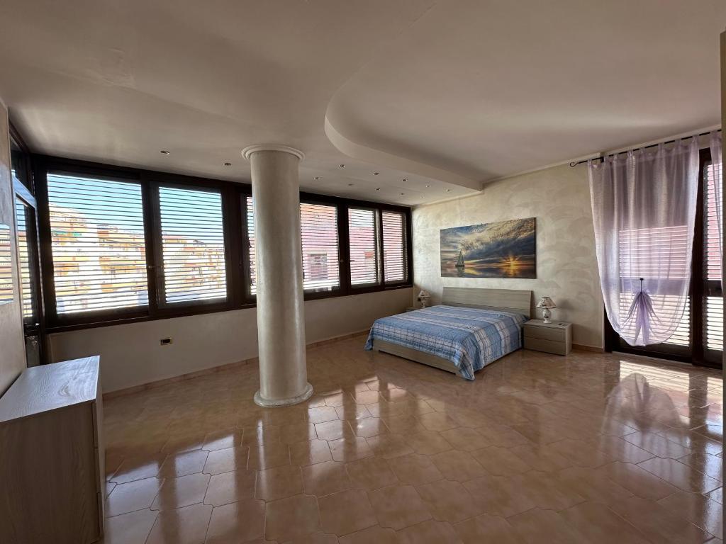 a bedroom with a bed in a room with windows at Dimora Signore Gallipoli lido in Gallipoli