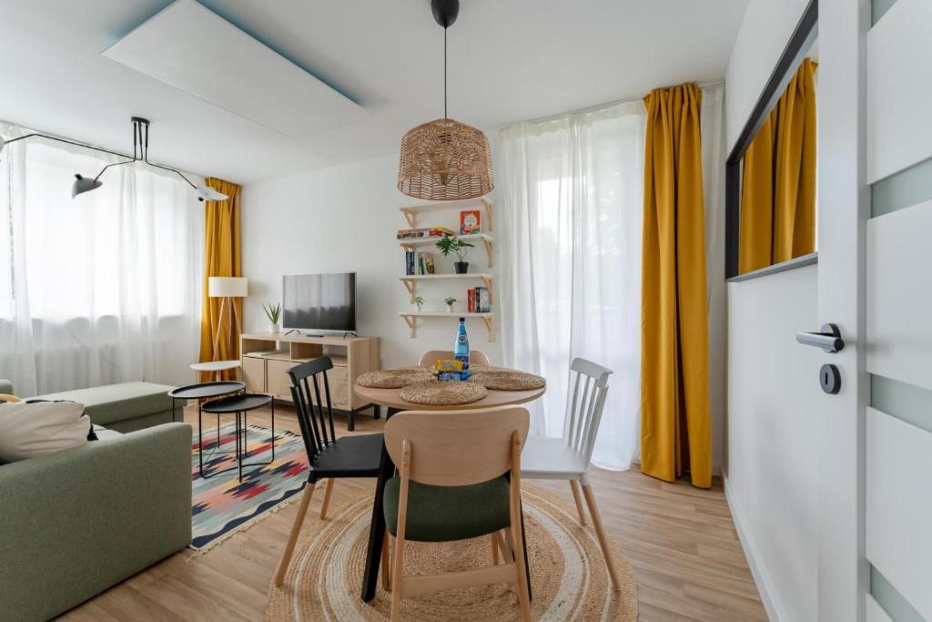 Una sala de estar con una mesa y sillas y un sofá. en Apartament w Góry! - przytulny blisko centrum - by SpaceApart, en Szklarska Poręba