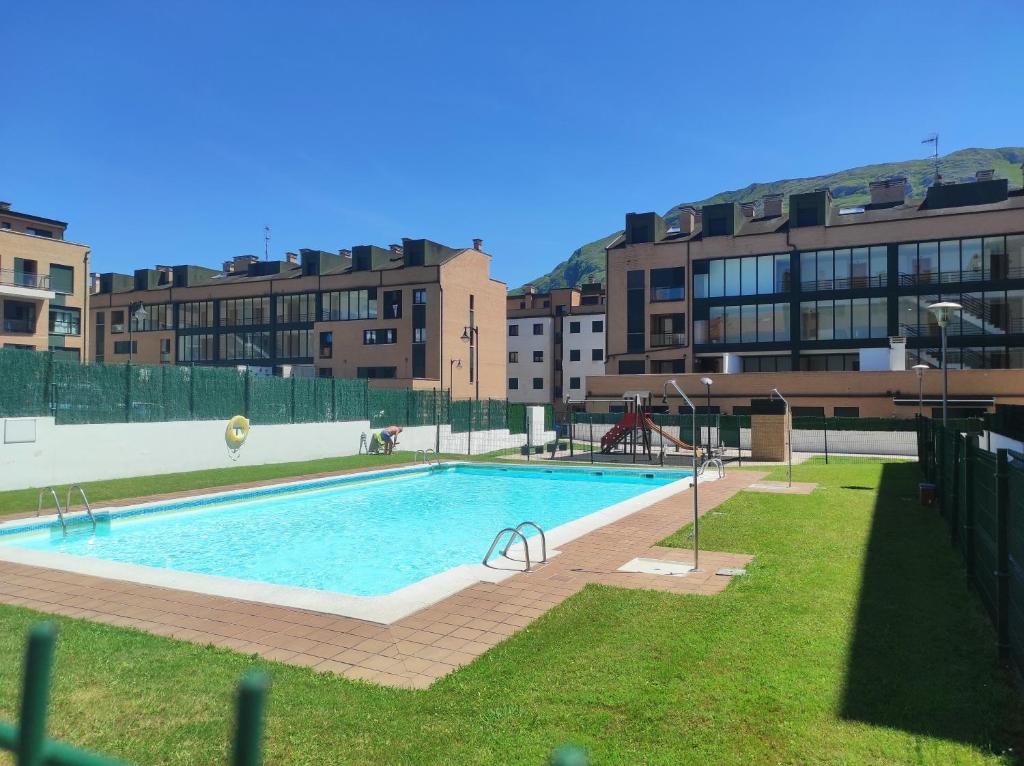 a large swimming pool in front of some buildings at Apartamento Sarastur in Posada de Llanes