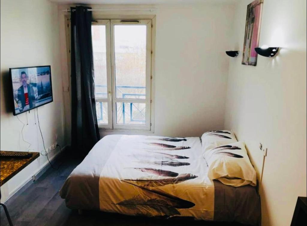 une chambre avec un lit et une fenêtre avec vue dans l'établissement S2 Bel appartement 10min centre Paris stade de France, à Saint-Denis