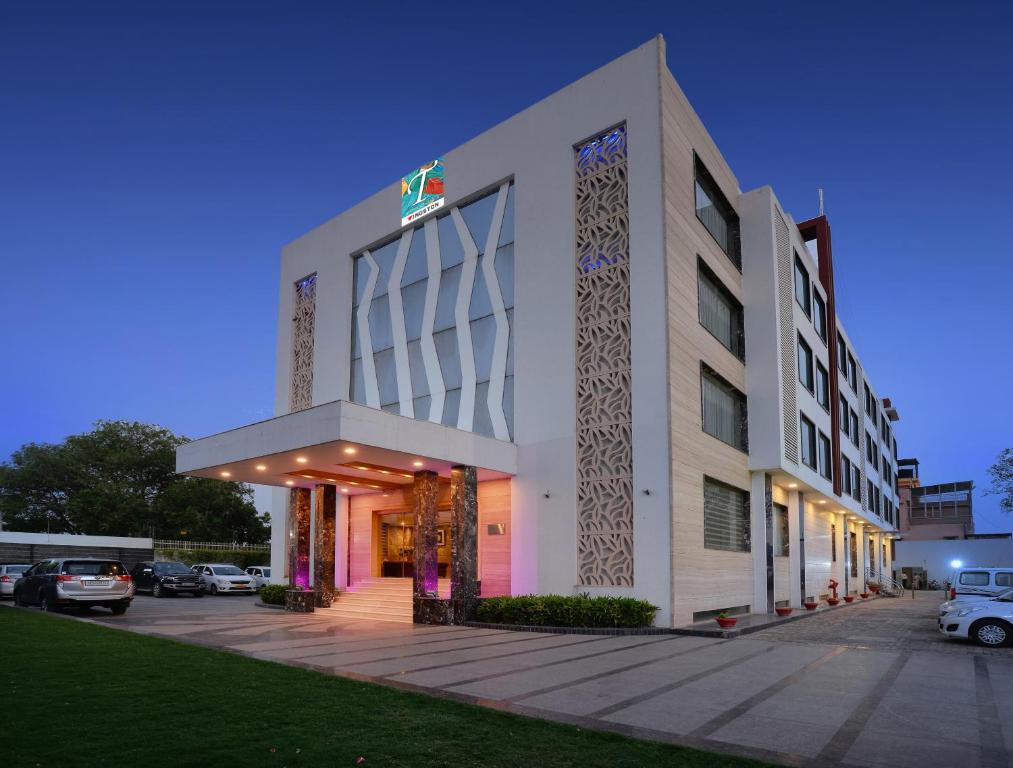a building with a parking lot in front of it at Wingston A TreeHouse Hotel, Goverdhan in Govardhan