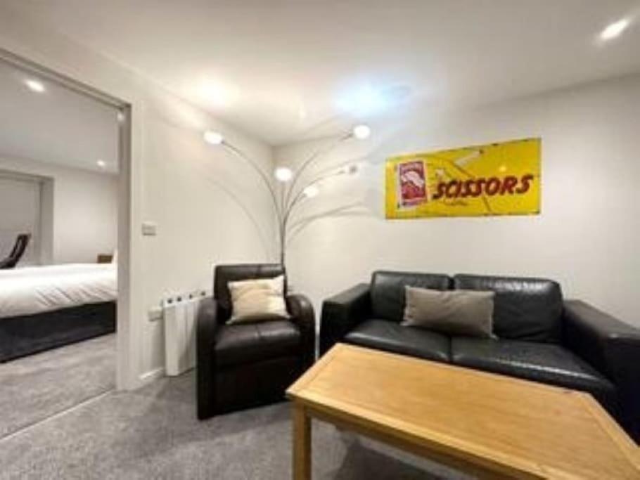 a living room with a couch and a bed at Modern Ground Floor Apartment in Midsomer Norton