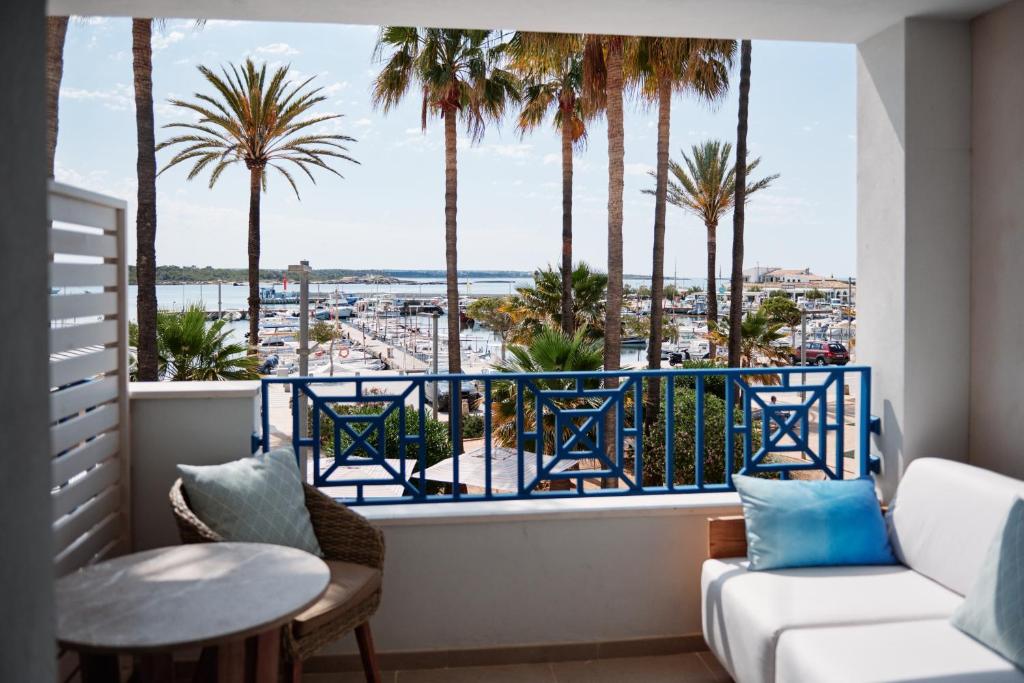 einen Balkon mit Palmen und Meerblick in der Unterkunft Hotel Honucai in Colonia Sant Jordi