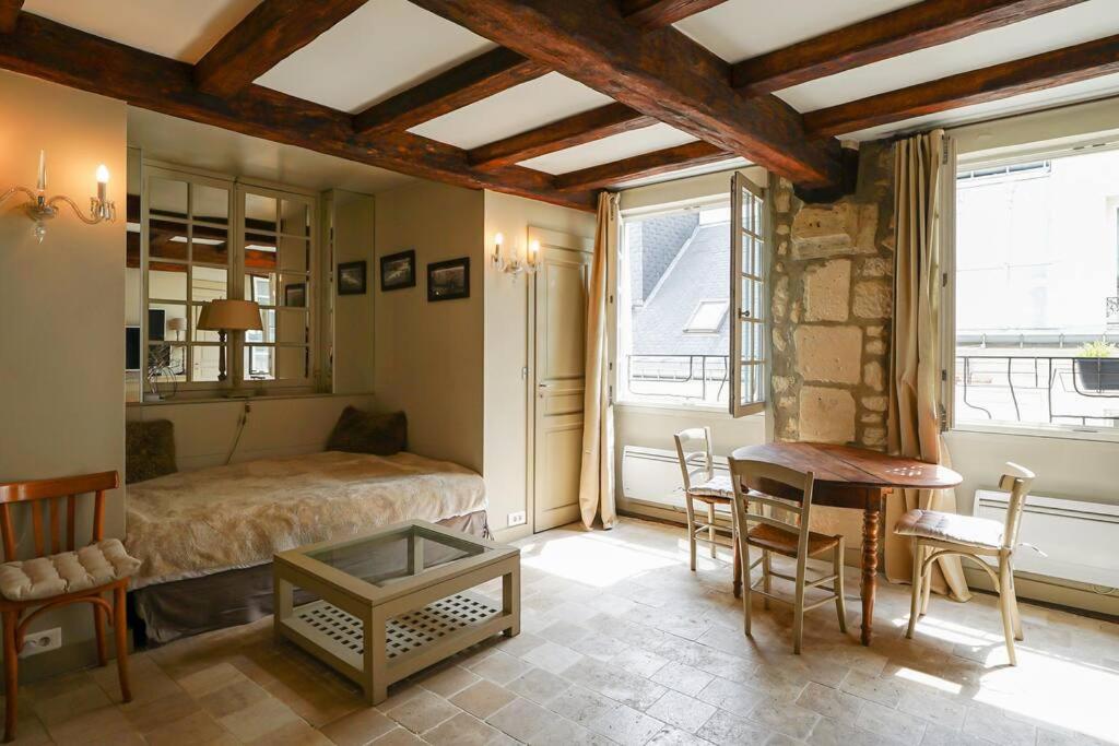 une chambre avec un lit, une table et des chaises dans l'établissement Cœur du Marais - Grand appartement 4 personnes, à Paris
