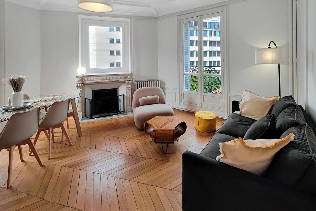 un salon avec un canapé noir et une table dans l'établissement Amazing refurbished flat in Paris V, à Paris