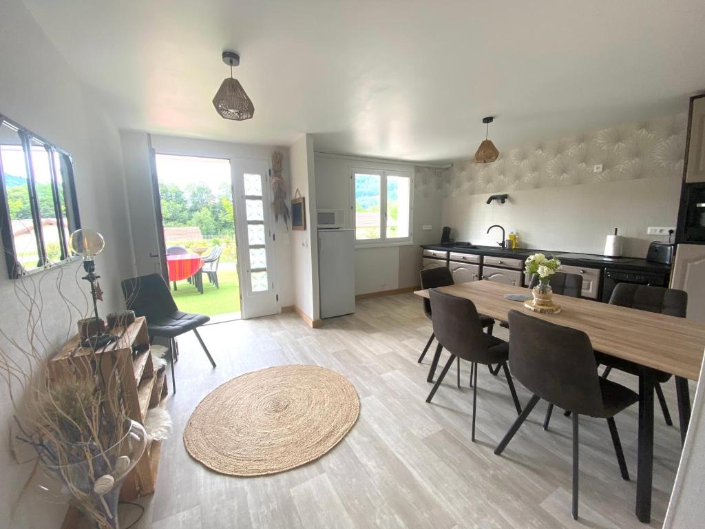 une cuisine et une salle à manger avec une table et des chaises dans l'établissement La maison de Cécile, à Vallières