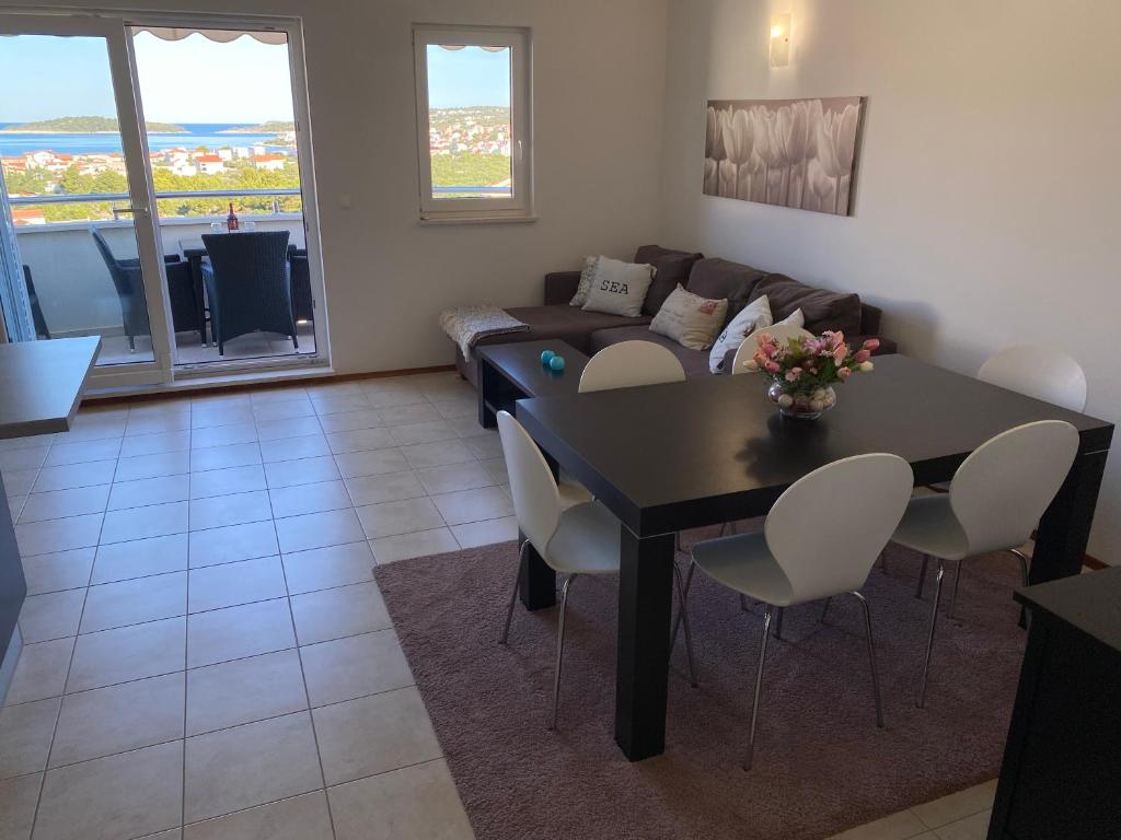 a living room with a table and a couch at Apartment Bumbar Sunset in Rogoznica