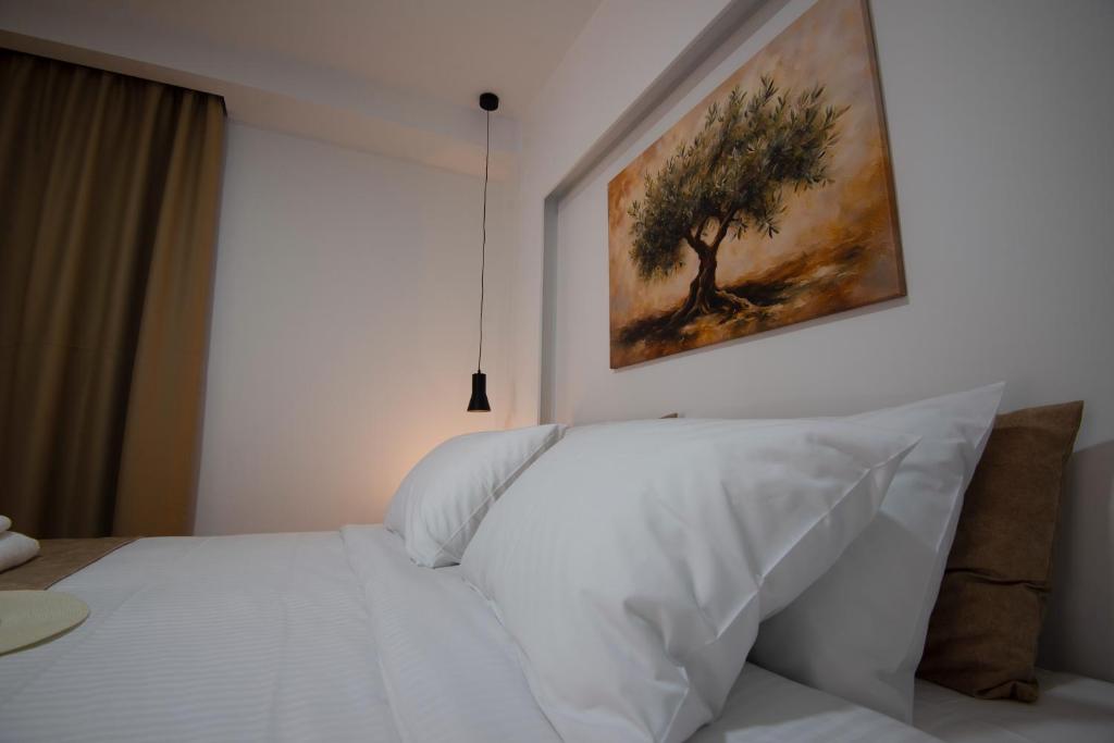 a bedroom with a white bed with a painting on the wall at Casa Nefeli in Karteros