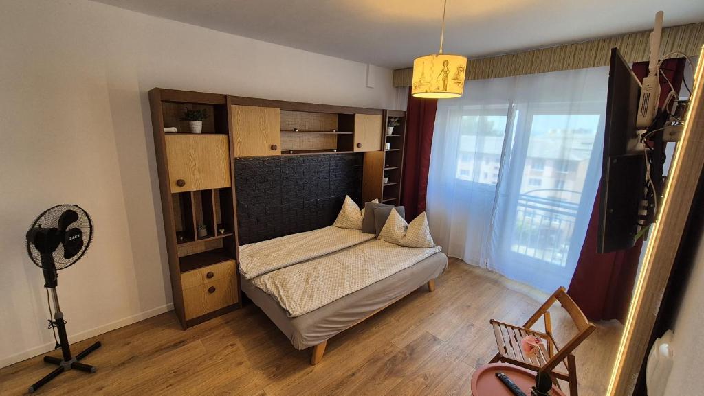 Una pequeña habitación con una cama y una ventana. en Valentina Studio, en Baia Mare