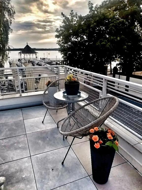 stół i krzesła na balkonie z widokiem na wodę w obiekcie Apartament Port w Ostródzie