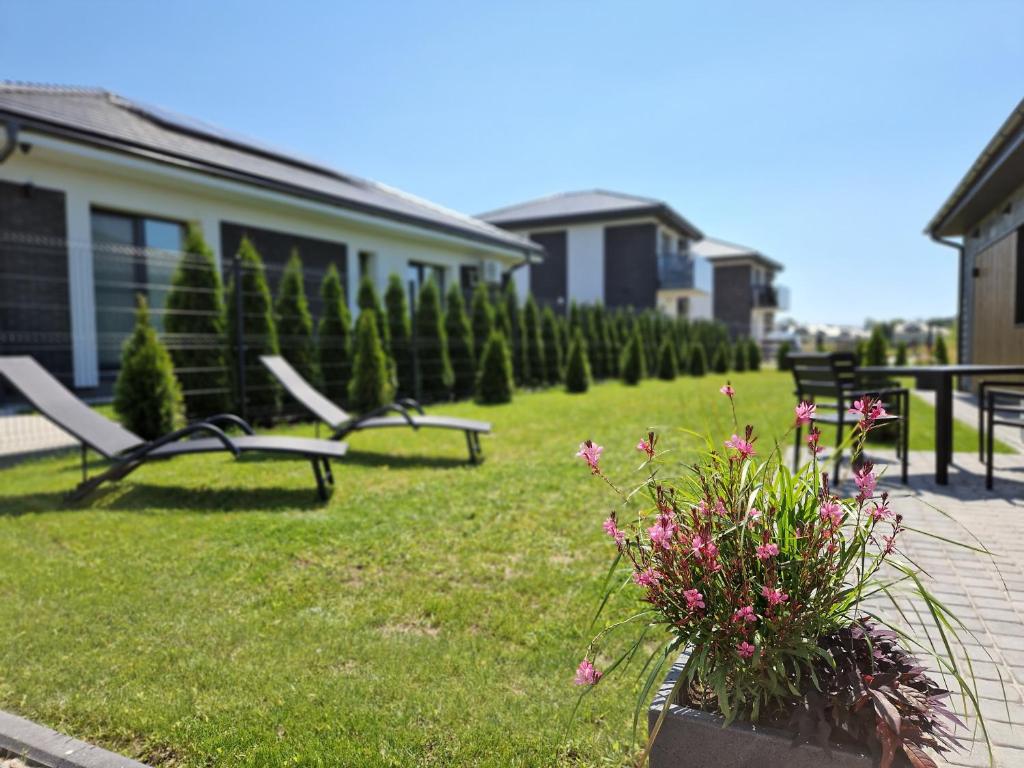 パランガにあるAmber Sea Apartment - 1の芝生の中にベンチ2つと花が咲く庭